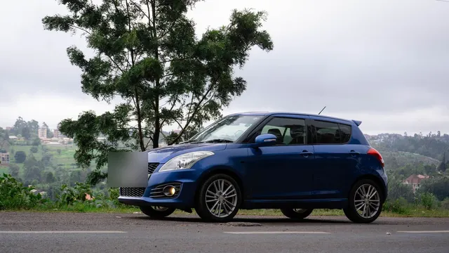Lacivert hatchback, tepede yol kenarında