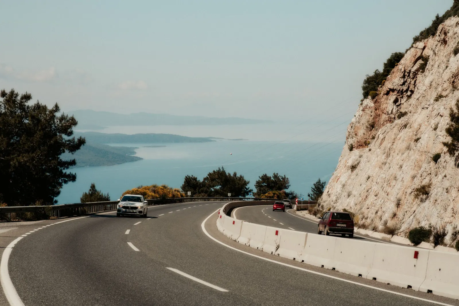 Deniz kıyısında kayalık yamaca yaslanan virajlı yol