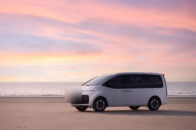 Beyaz minivan, gün batımında kumsalda